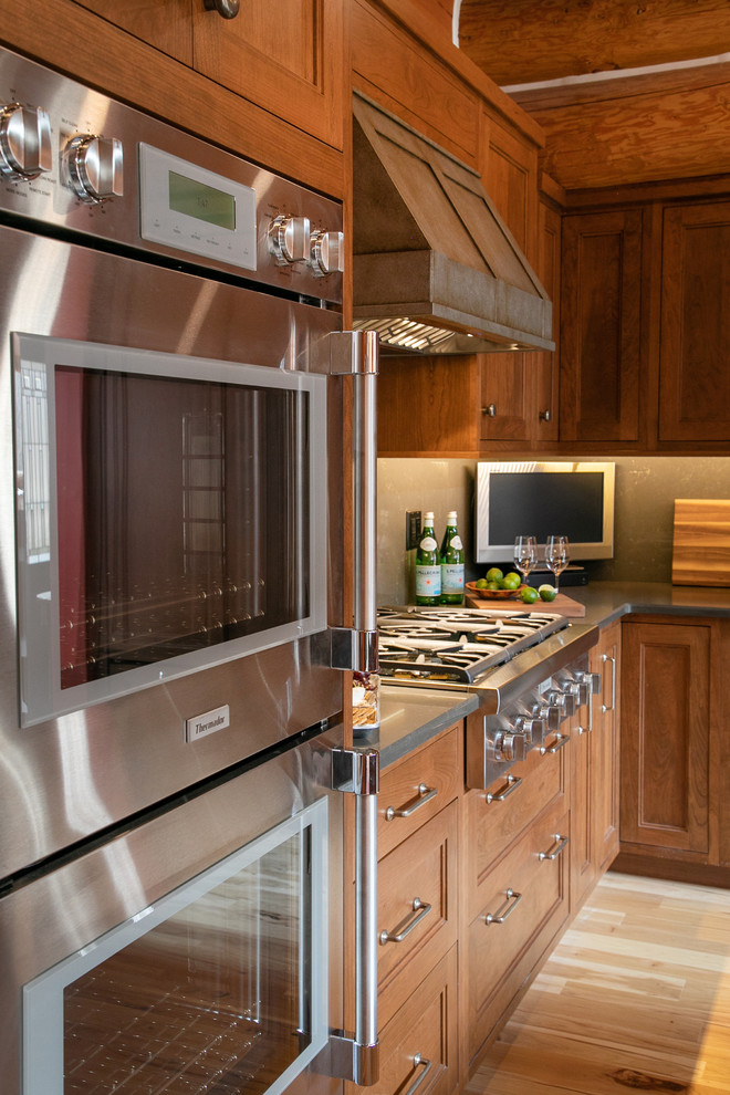 Mid-sized mountain style l-shaped light wood floor open concept kitchen photo in Milwaukee with recessed-panel cabinets, medium tone wood cabinets, quartz countertops, gray backsplash, stone slab backsplash, stainless steel appliances and gray countertops