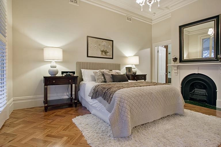 Traditional master bedroom in Melbourne with medium hardwood floors, a stone fireplace surround and a standard fireplace.