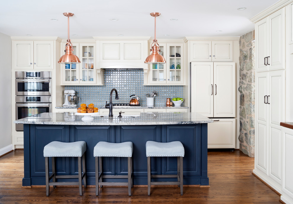 Mid-sized traditional galley open plan kitchen in DC Metro with a farmhouse sink, granite benchtops, blue splashback, ceramic splashback, panelled appliances, with island, raised-panel cabinets, white cabinets and dark hardwood floors.