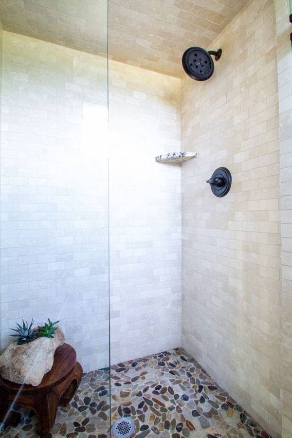 This is an example of a small transitional master bathroom in Denver with medium wood cabinets, an alcove shower, beige walls, granite benchtops, brown floor, a hinged shower door, multi-coloured benchtops, recessed-panel cabinets, beige tile, subway tile, slate floors and an undermount sink.