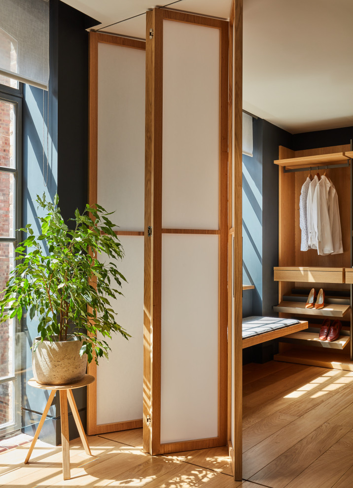 Foto de armario vestidor de hombre minimalista pequeño con suelo de madera en tonos medios, armarios abiertos y puertas de armario de madera clara