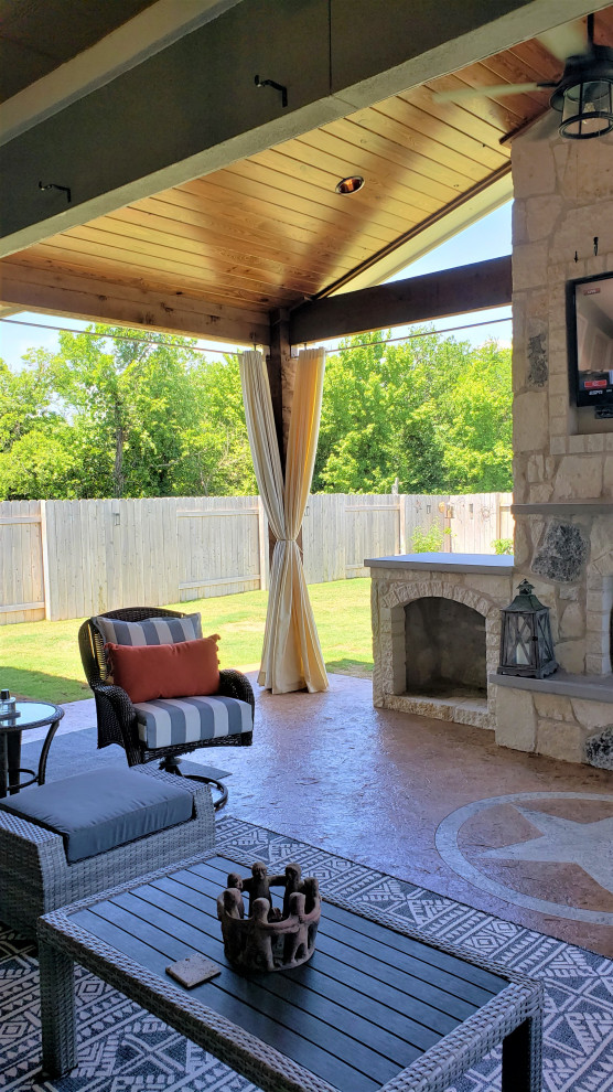 Inspiration for a country backyard patio in Austin with with fireplace and a roof extension.
