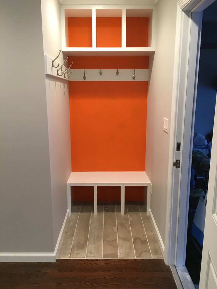 Design ideas for a small contemporary mudroom in New York with orange walls and porcelain floors.