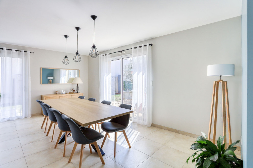 Cette photo montre une salle à manger scandinave avec un mur beige, un sol en carrelage de céramique et un sol beige.