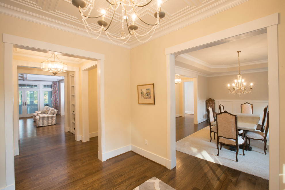 Photo of a large transitional foyer in Baltimore with yellow walls, medium hardwood floors, a double front door, a dark wood front door and brown floor.