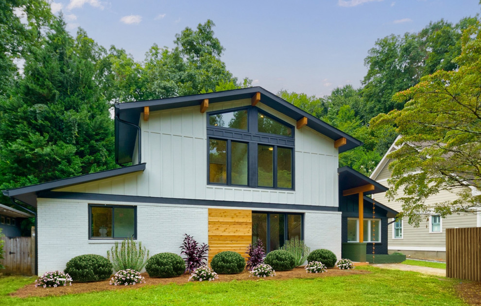 Ejemplo de fachada de casa gris y negra retro de tamaño medio de dos plantas con revestimientos combinados, tejado a dos aguas, tejado de teja de madera y panel y listón
