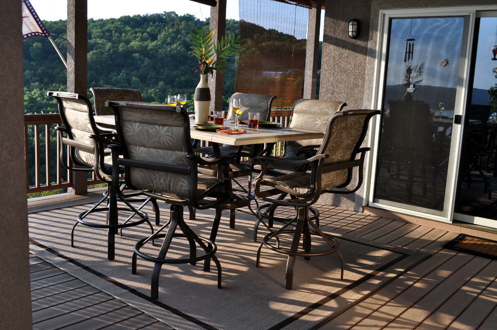Example of a mid-sized transitional backyard deck design with a roof extension