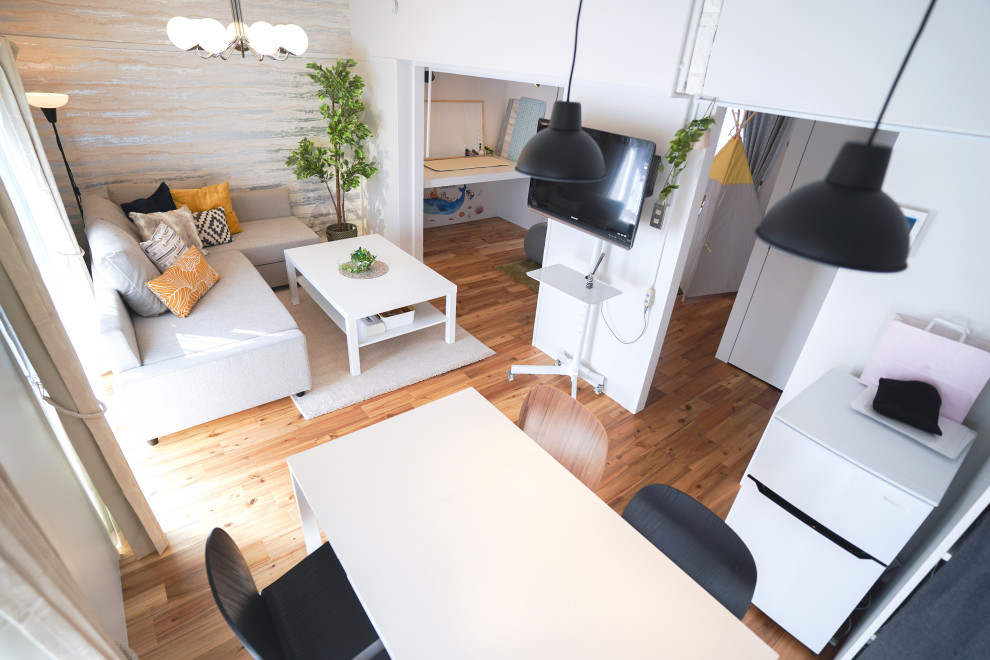 Imagen de sala de estar abierta nórdica con paredes blancas, suelo de madera pintada y televisor independiente