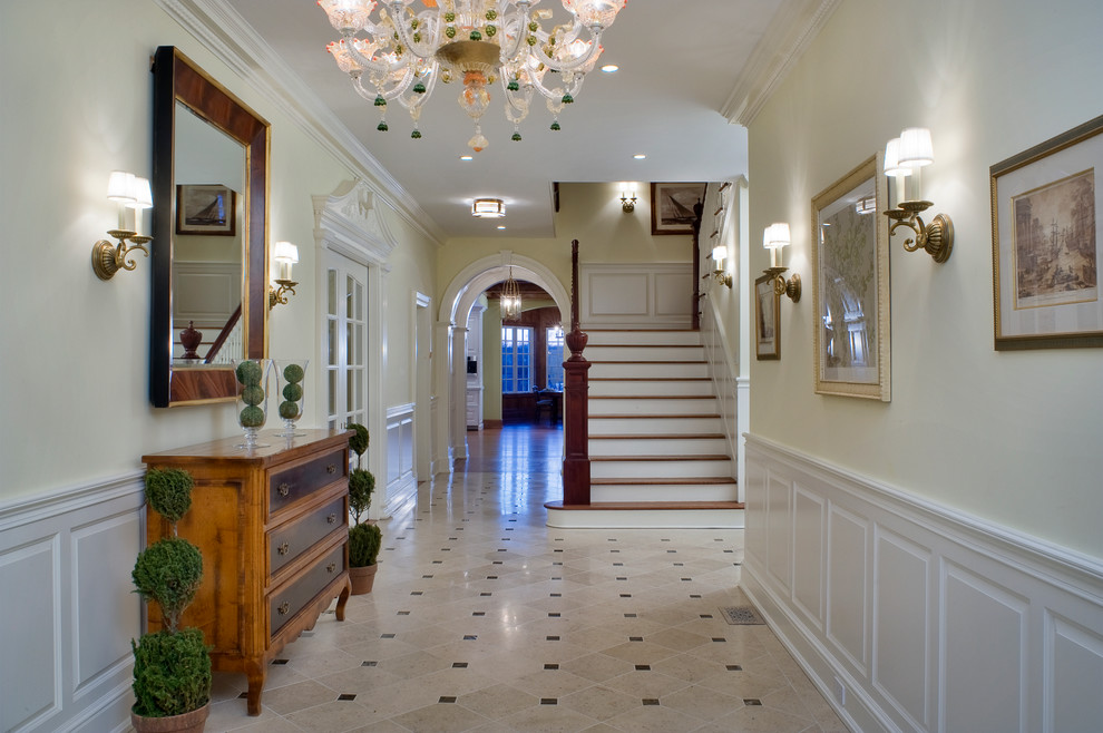 Large traditional foyer in New York with beige walls and ceramic floors.