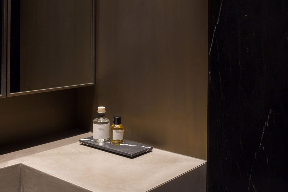 Inspiration for a mid-sized contemporary 3/4 bathroom in New York with dark wood cabinets, an open shower, black tile, stone slab, brown walls, concrete floors and concrete benchtops.