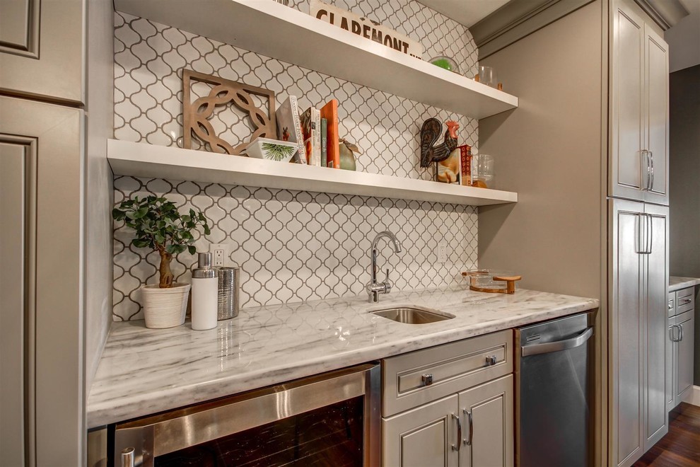 Design ideas for a mid-sized transitional single-wall wet bar in Phoenix with an undermount sink, shaker cabinets, grey cabinets, marble benchtops, white splashback, porcelain splashback and dark hardwood floors.