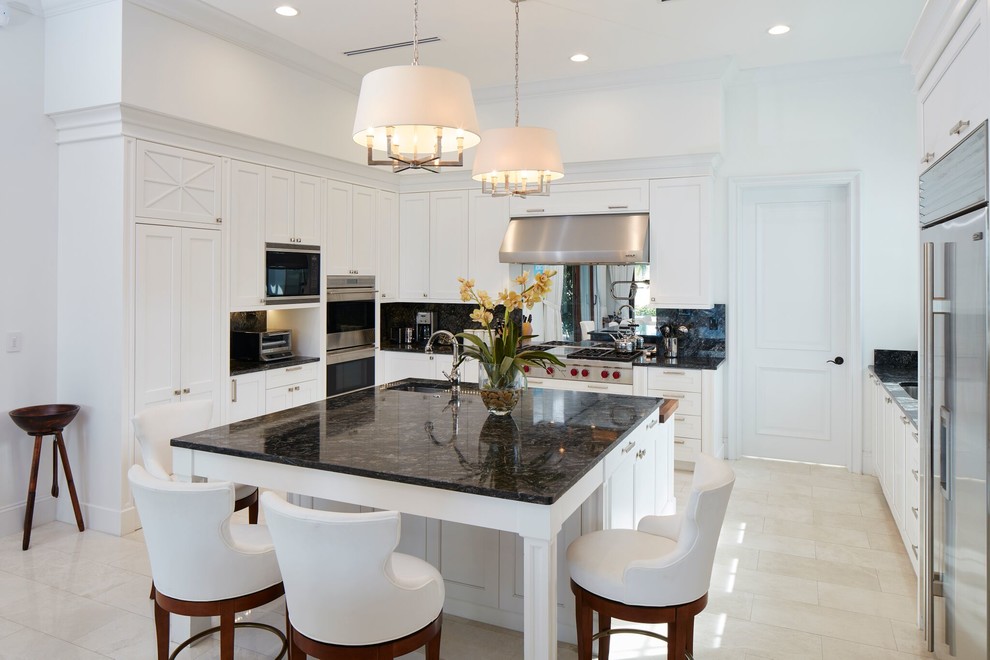 Inspiration for a transitional u-shaped beige floor kitchen remodel with an undermount sink, shaker cabinets, black backsplash, stainless steel appliances, an island and black countertops