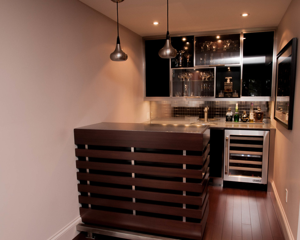 Inspiration for a small contemporary single-wall wet bar in Other with an undermount sink, glass-front cabinets, black cabinets, solid surface benchtops, grey splashback, mirror splashback, dark hardwood floors and brown floor.