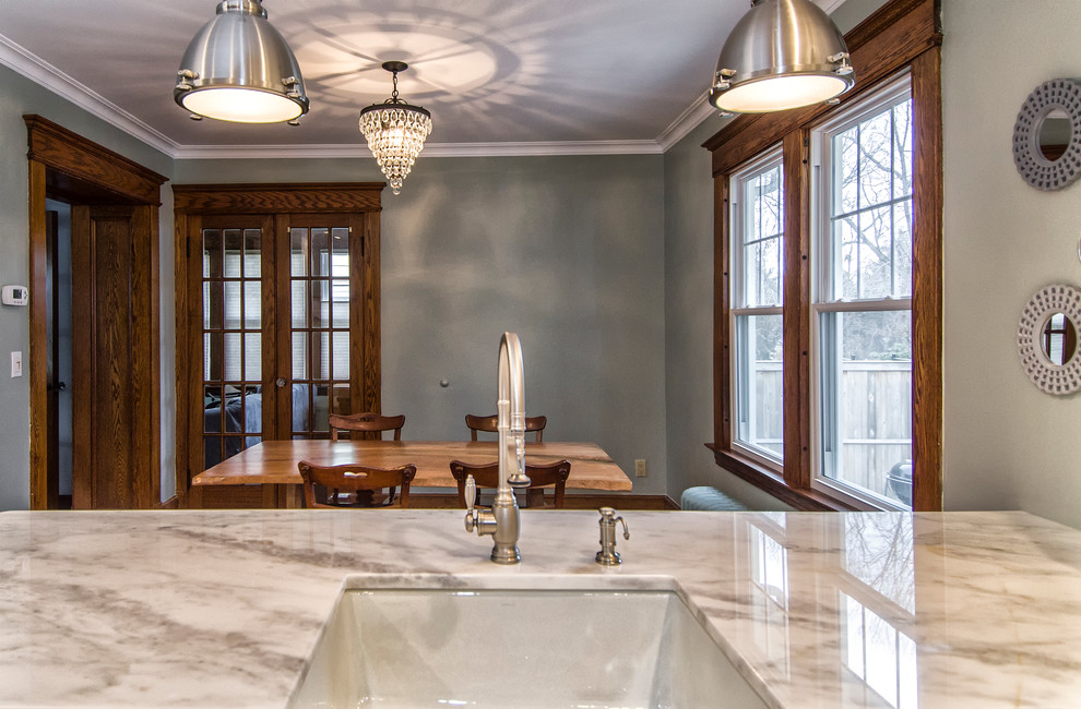 Eat-in kitchen - mid-sized transitional u-shaped medium tone wood floor and brown floor eat-in kitchen idea in Bridgeport with a farmhouse sink, recessed-panel cabinets, white cabinets, marble countertops, gray backsplash, subway tile backsplash, stainless steel appliances and a peninsula