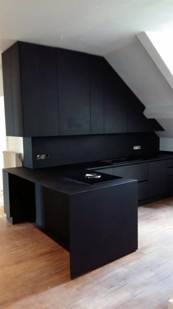 Inspiration for a mid-sized modern l-shaped open plan kitchen in Turin with an integrated sink, black appliances, light hardwood floors and wood.