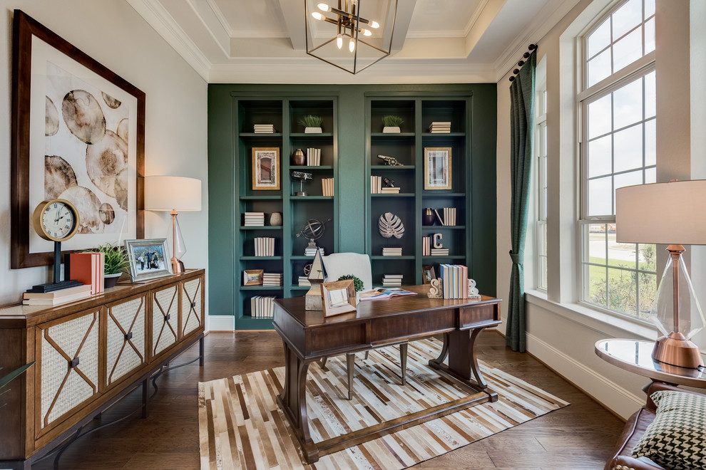 This is an example of a transitional home office in Houston with green walls, dark hardwood floors, a freestanding desk and brown floor.