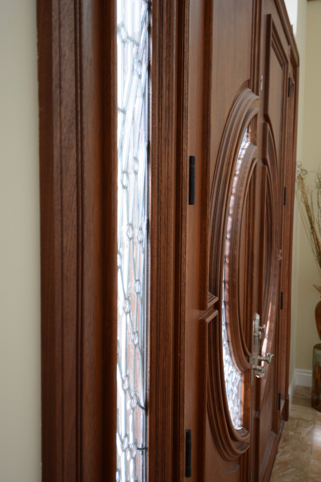 Example of a large transitional beige floor front door design in Orange County with beige walls and a dark wood front door
