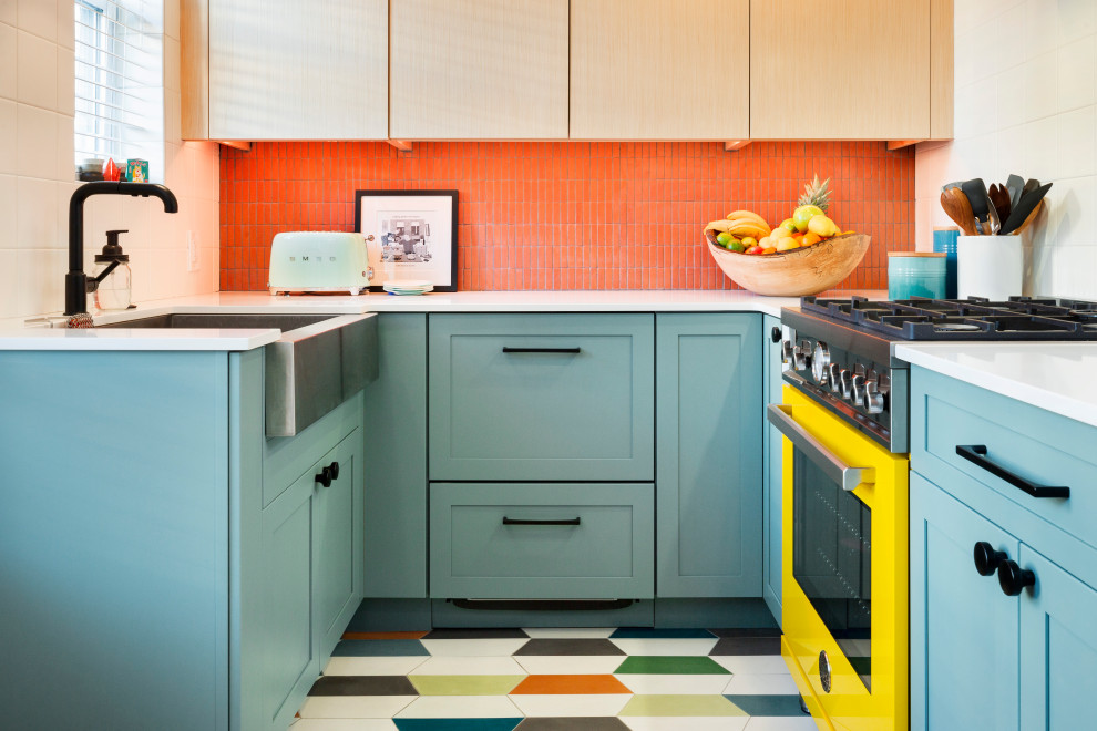 Eclectic kitchen in Philadelphia with a farmhouse sink, flat-panel cabinets, light wood cabinets, quartz benchtops, white splashback, mosaic tile splashback, coloured appliances, cement tiles, multi-coloured floor and red benchtop.