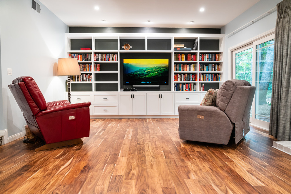 This is an example of a large eclectic enclosed living room in Los Angeles with a library, blue walls, dark hardwood floors and a built-in media wall.