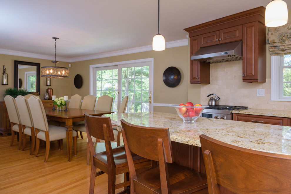 Small transitional l-shaped eat-in kitchen in Boston with raised-panel cabinets, medium wood cabinets, granite benchtops, beige splashback, subway tile splashback, stainless steel appliances, medium hardwood floors, with island and brown floor.