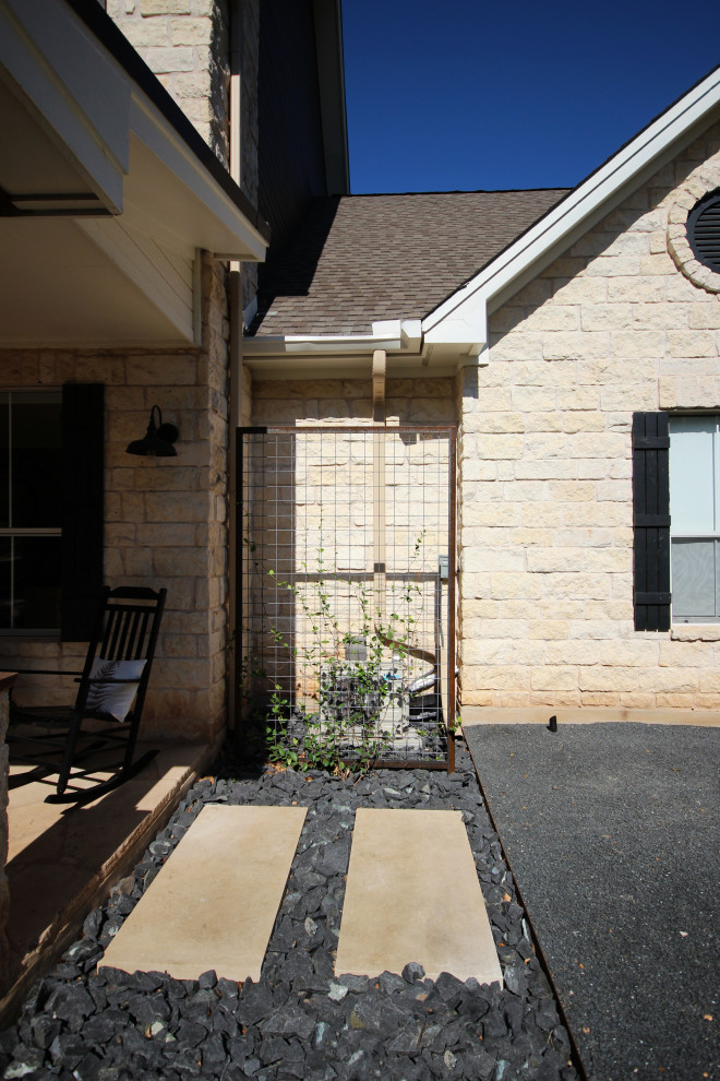 Expansive contemporary front yard driveway in Austin with with path and gravel.