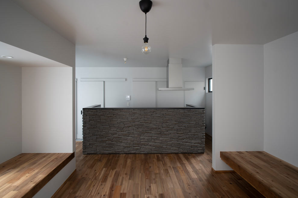 Design ideas for a medium sized modern single-wall open plan kitchen in Other with a single-bowl sink, beaded cabinets, black cabinets, composite countertops, metallic splashback, black appliances, concrete flooring, grey floors, black worktops and a timber clad ceiling.
