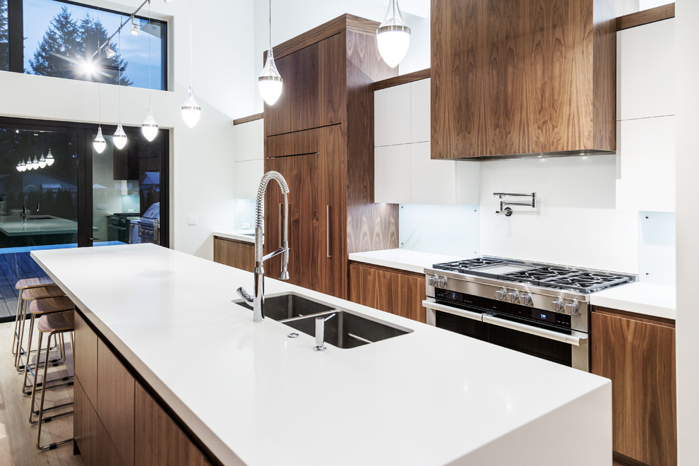 Inspiration for a large modern single-wall eat-in kitchen in Portland with a double-bowl sink, flat-panel cabinets, quartz benchtops, white splashback, glass sheet splashback, panelled appliances, bamboo floors, with island, beige floor and medium wood cabinets.
