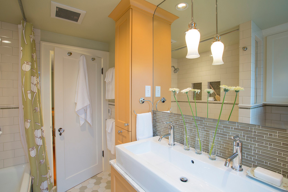 Small traditional bathroom in Portland with a trough sink, a shower/bathtub combo, recessed-panel cabinets, green tile, glass tile, marble benchtops, green walls, ceramic floors and yellow cabinets.