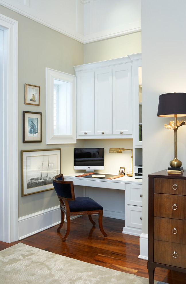 Photo of a small traditional study room in Other with a built-in desk, beige walls, dark hardwood floors and no fireplace.