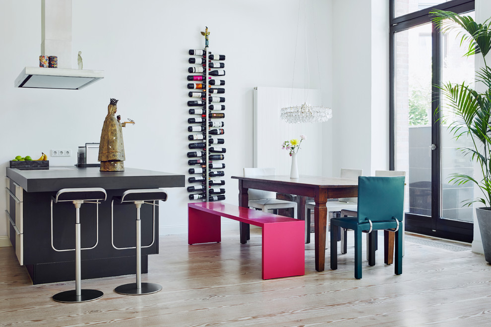 This is an example of a mid-sized eclectic open plan dining in Dusseldorf with white walls and light hardwood floors.