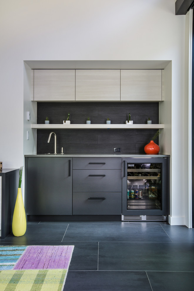 Inspiration for a country single-wall wet bar in Other with flat-panel cabinets, black cabinets, black splashback, black floor and grey benchtop.