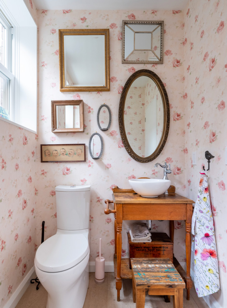 Inspiration pour un grand WC et toilettes design en bois vieilli avec un placard sans porte, WC à poser, un mur rose, parquet clair, une vasque, un plan de toilette en bois, un sol marron, un plan de toilette marron, meuble-lavabo sur pied et du papier peint.