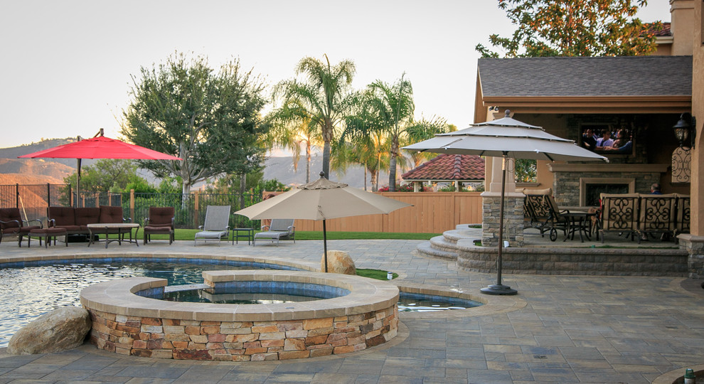 This is an example of a large traditional backyard patio in San Diego with an outdoor kitchen, concrete pavers and a pergola.
