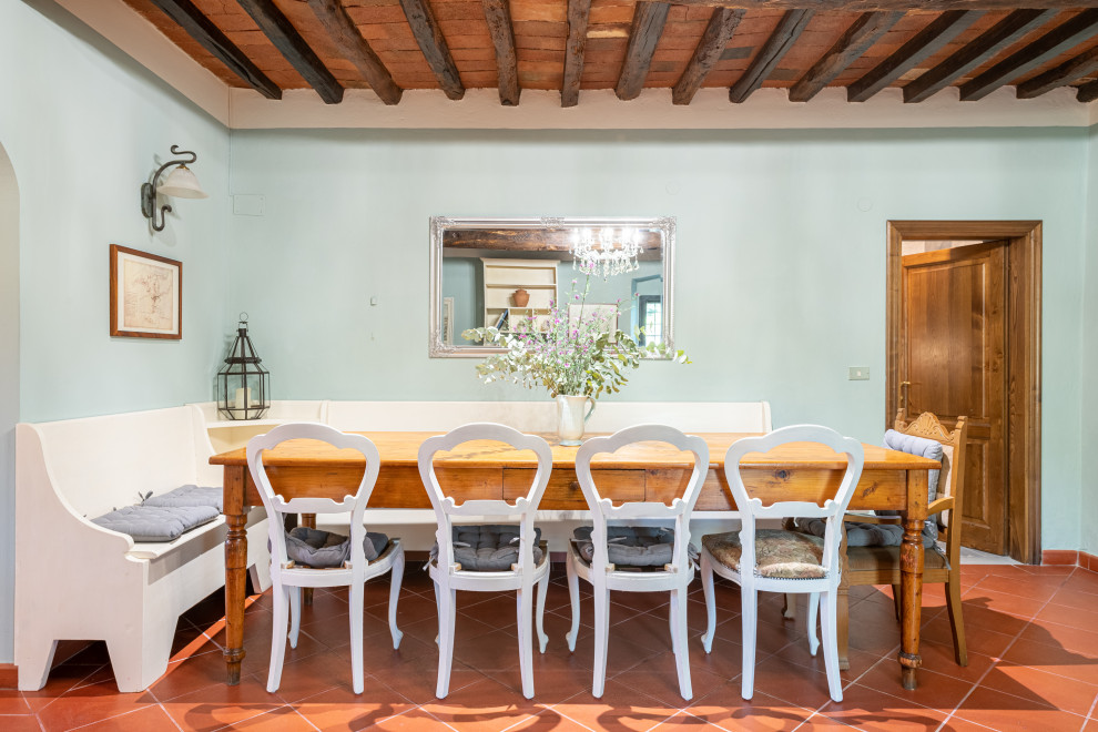Идея дизайна: кухня-столовая в средиземноморском стиле с полом из терракотовой плитки, оранжевым полом и балками на потолке