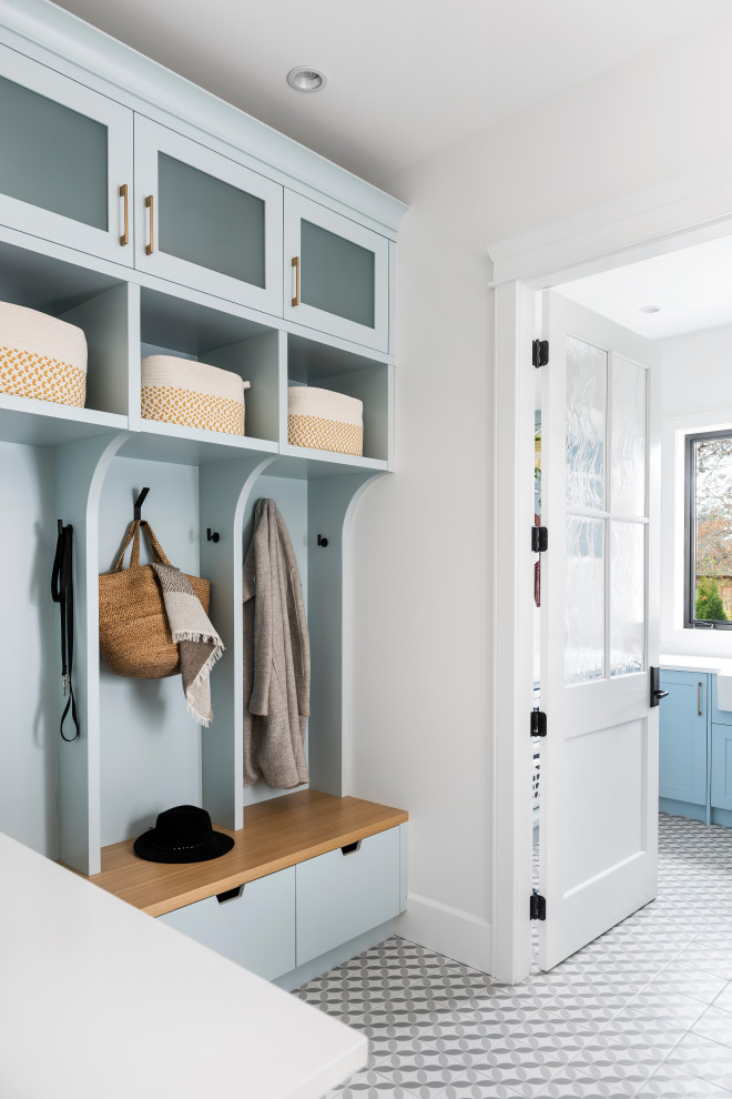 Example of a transitional multicolored floor mudroom design with white walls and a white front door