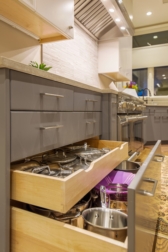 This is an example of a large modern l-shaped eat-in kitchen in Austin with an undermount sink, flat-panel cabinets, grey cabinets, quartz benchtops, beige splashback, matchstick tile splashback, stainless steel appliances, light hardwood floors and with island.