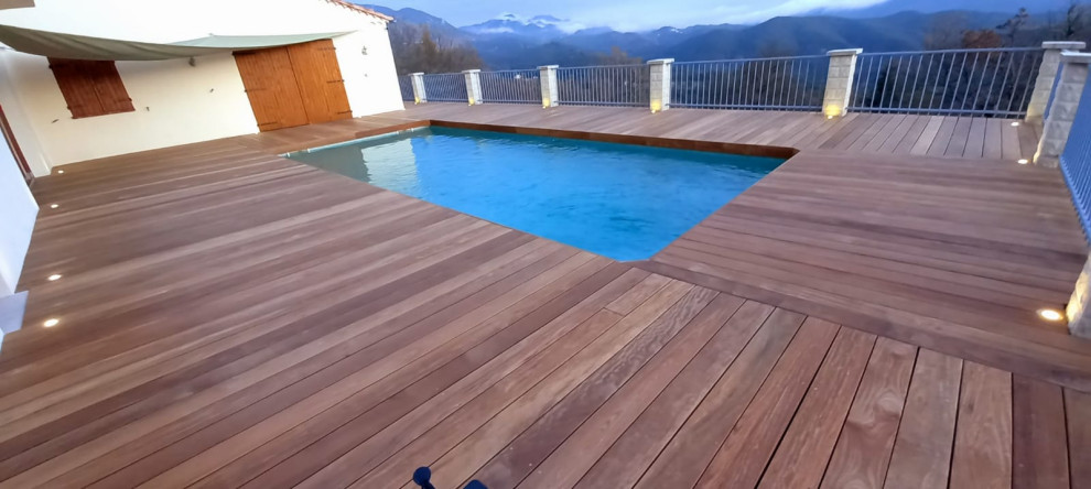 Exemple d'une grande terrasse arrière et au rez-de-chaussée montagne avec aucune couverture et un garde-corps en métal.