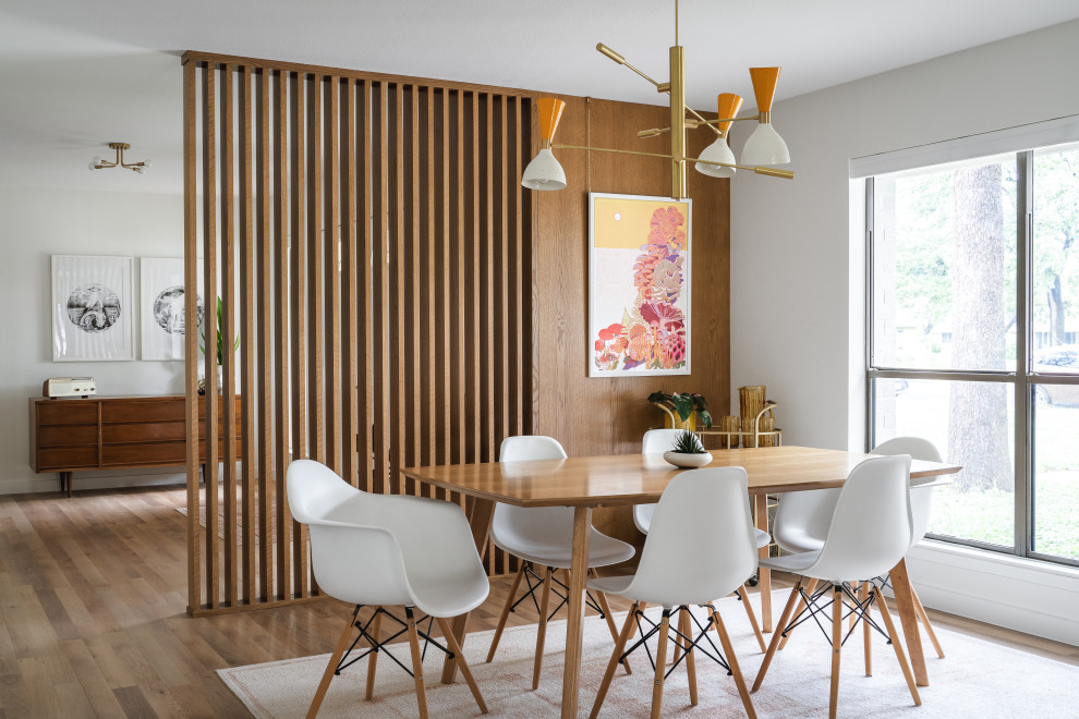Foto di una sala da pranzo moderna con pareti bianche, pavimento in legno massello medio, pavimento marrone e pareti in legno