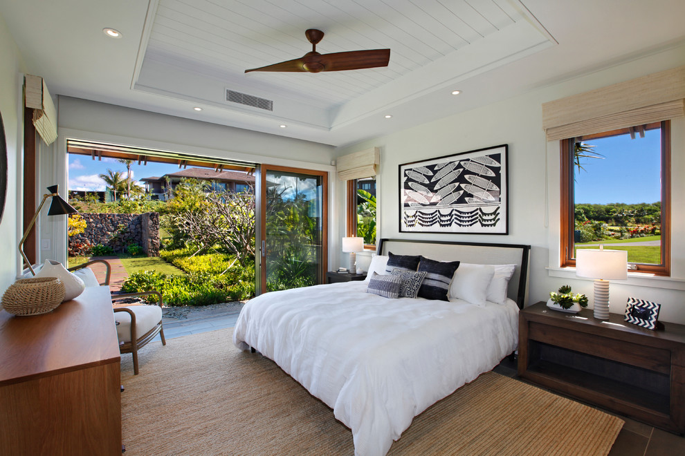 This is an example of a mid-sized tropical master bedroom in Hawaii with white walls and no fireplace.
