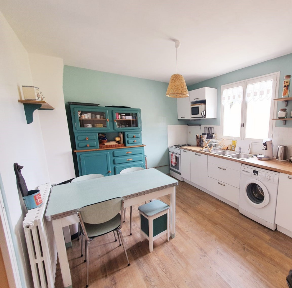 Photo of a mid-sized midcentury single-wall separate kitchen in Paris with an undermount sink, flat-panel cabinets, white cabinets, laminate benchtops, white splashback, ceramic splashback, white appliances, no island, brown floor and brown benchtop.