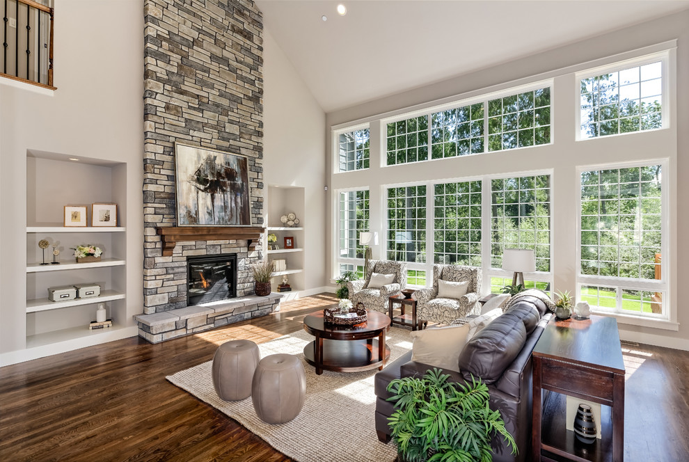 Photo of a traditional open concept family room in Seattle with grey walls, dark hardwood floors, a standard fireplace and a stone fireplace surround.