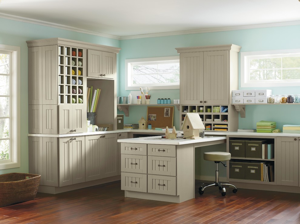 Example of a small classic built-in desk medium tone wood floor craft room design in New York with blue walls and no fireplace