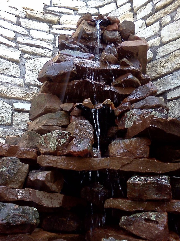 Photo of a small rustic full sun backyard water fountain landscape in Austin.