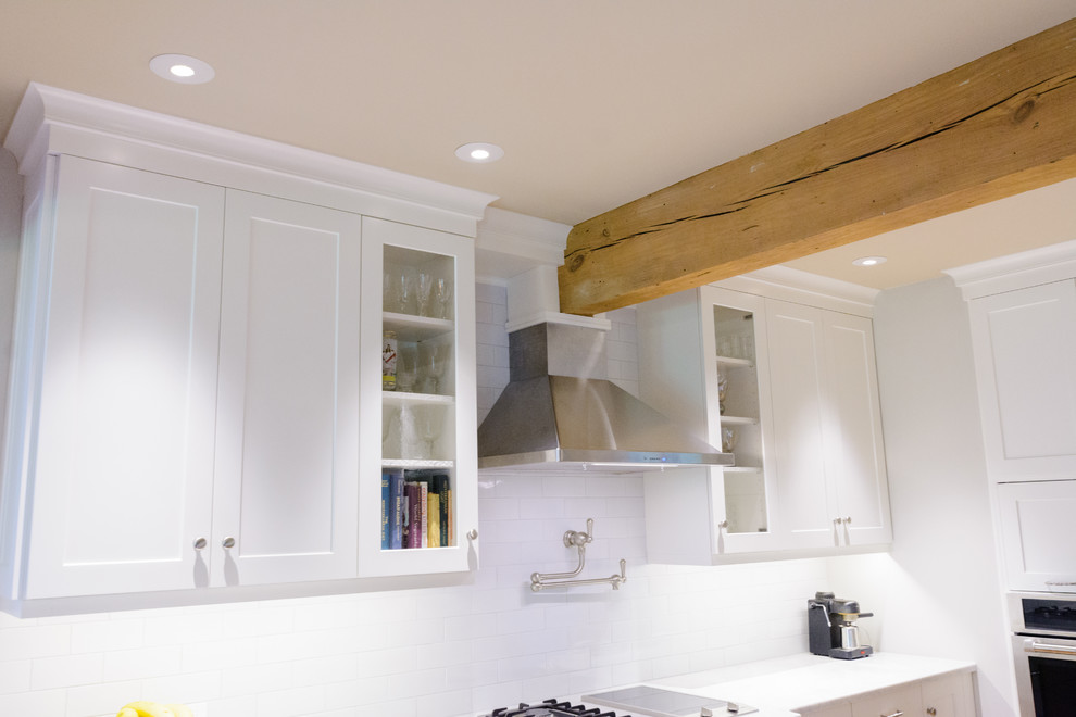 Example of a mid-sized transitional galley enclosed kitchen design in Charleston with white cabinets, white backsplash, no island and white countertops