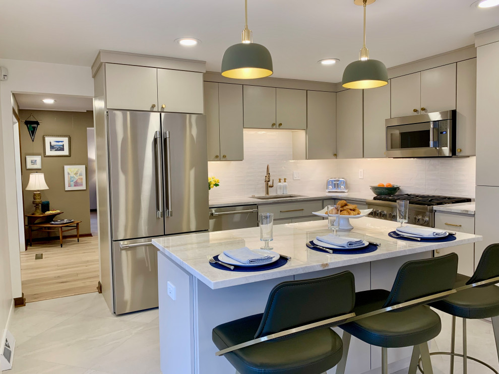 Example of a large minimalist l-shaped porcelain tile and beige floor kitchen pantry design with a single-bowl sink, flat-panel cabinets, beige cabinets, quartzite countertops, white backsplash, porcelain backsplash, stainless steel appliances, an island and beige countertops