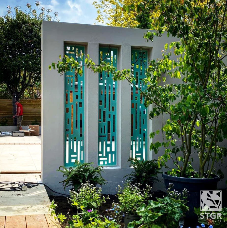 Foto di un giardino design esposto a mezz'ombra di medie dimensioni e dietro casa con pedane e recinzione in metallo