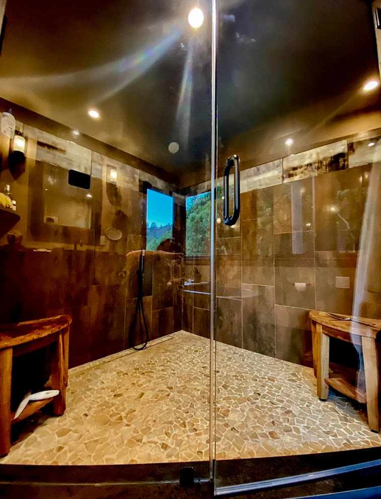 На фото: большая главная ванная комната в стиле рустика с отдельно стоящей ванной, угловым душем, бежевой плиткой, керамогранитной плиткой, бежевыми стенами, полом из керамогранита, врезной раковиной, коричневым полом, душем с распашными дверями и сиденьем для душа