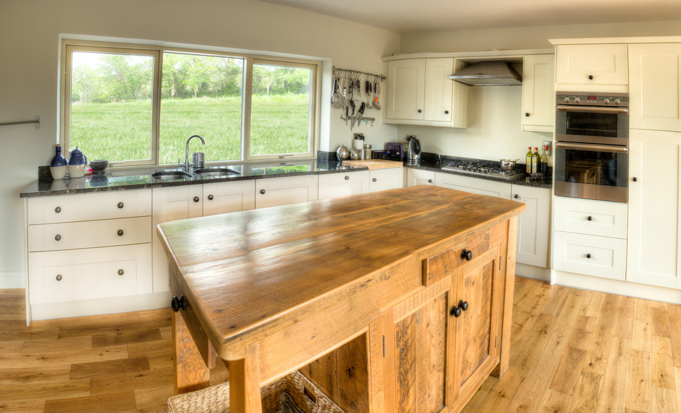 Design ideas for a country l-shaped open plan kitchen in Cork with medium hardwood floors and with island.