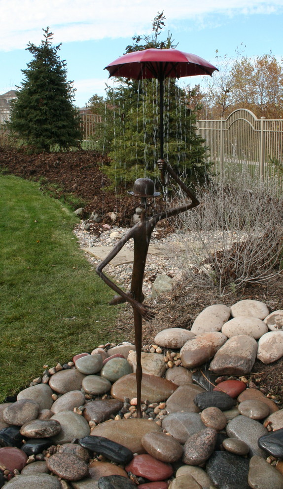 Mid-sized eclectic garden in Omaha with a water feature and gravel.