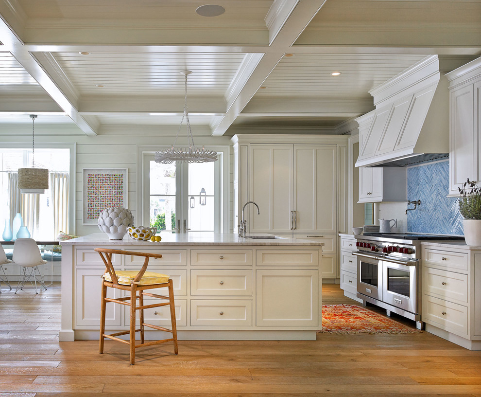 Design ideas for a beach style kitchen in Jacksonville with white cabinets, blue splashback and with island.